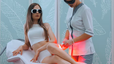 Medium-shot-of-patient's-legs-during-laser-hair-removal-procedure.-Unwanted-hair-and-laser-hair-removal-concept.
